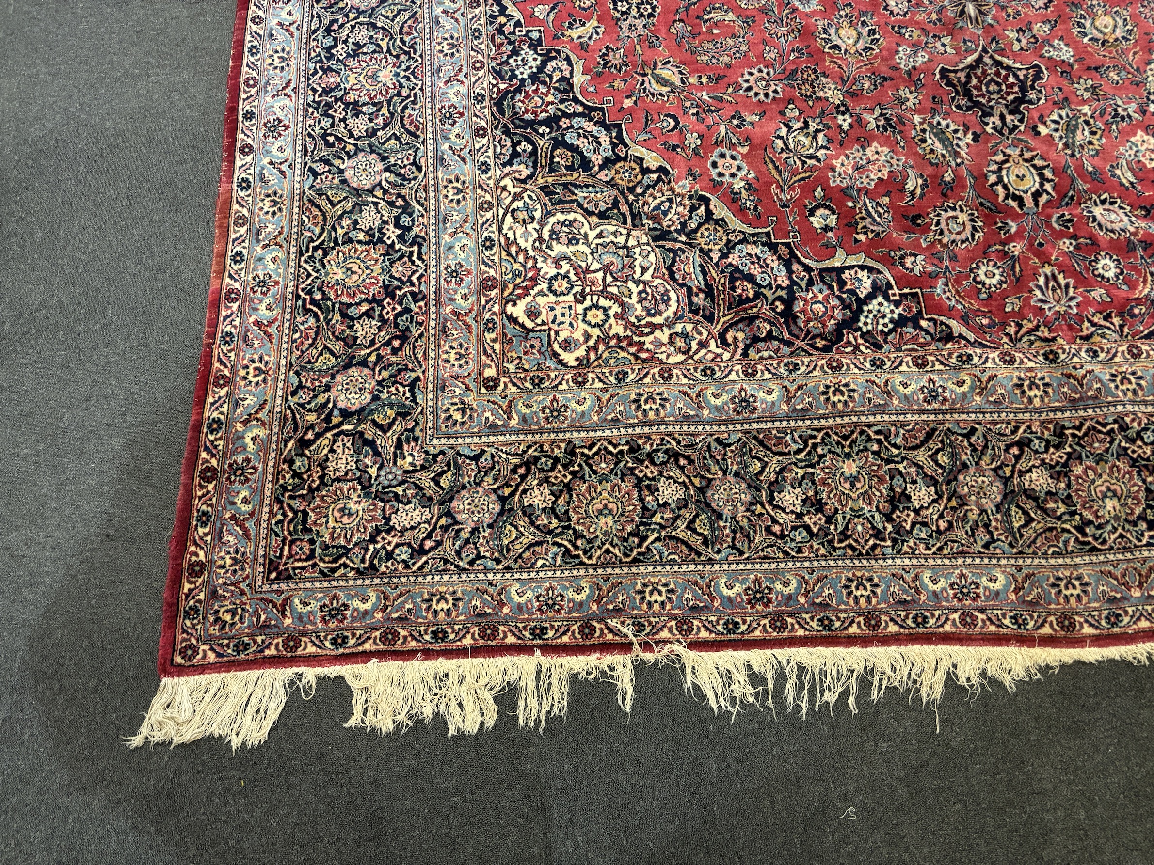 A Persian Kashan carpet with central medallion on a foliate red ground, multi bordered, 430 x 315cm